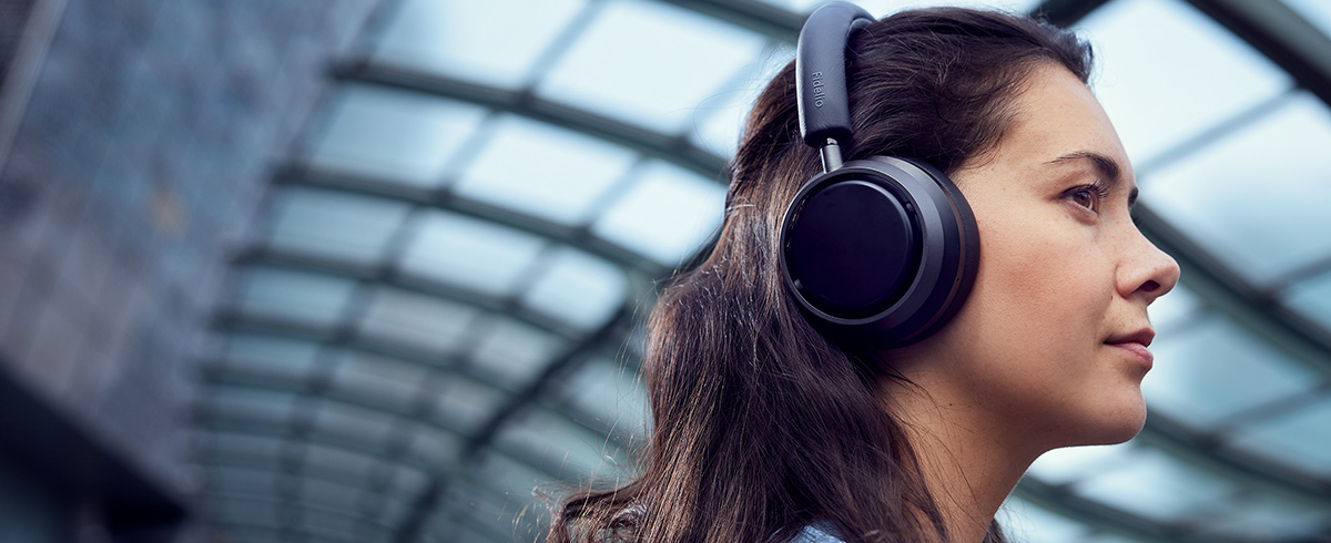 Žena uživa u glazbi na putovanju koristeći Philips L4 slu&scaron;alice