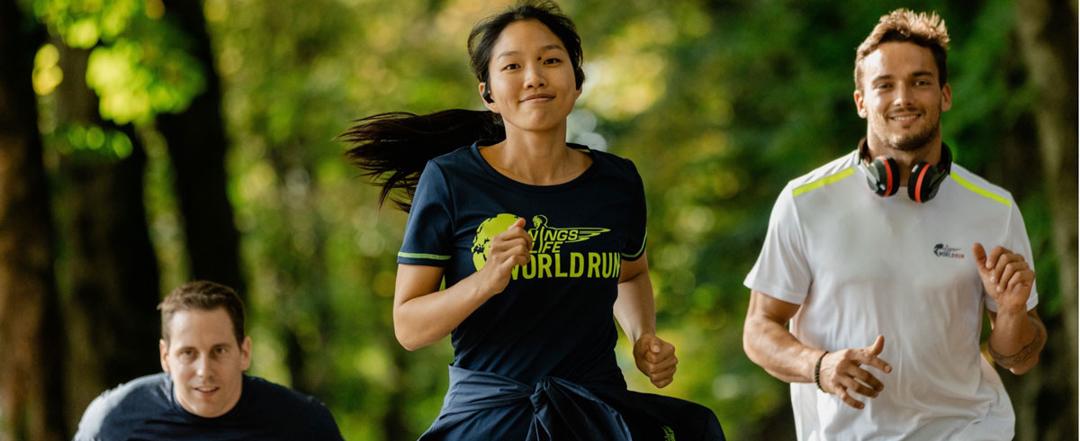 Tri sudionika utrke Wings for Life World Run radosno trče noseći sportske slu&scaron;alice tvrtke Philips.